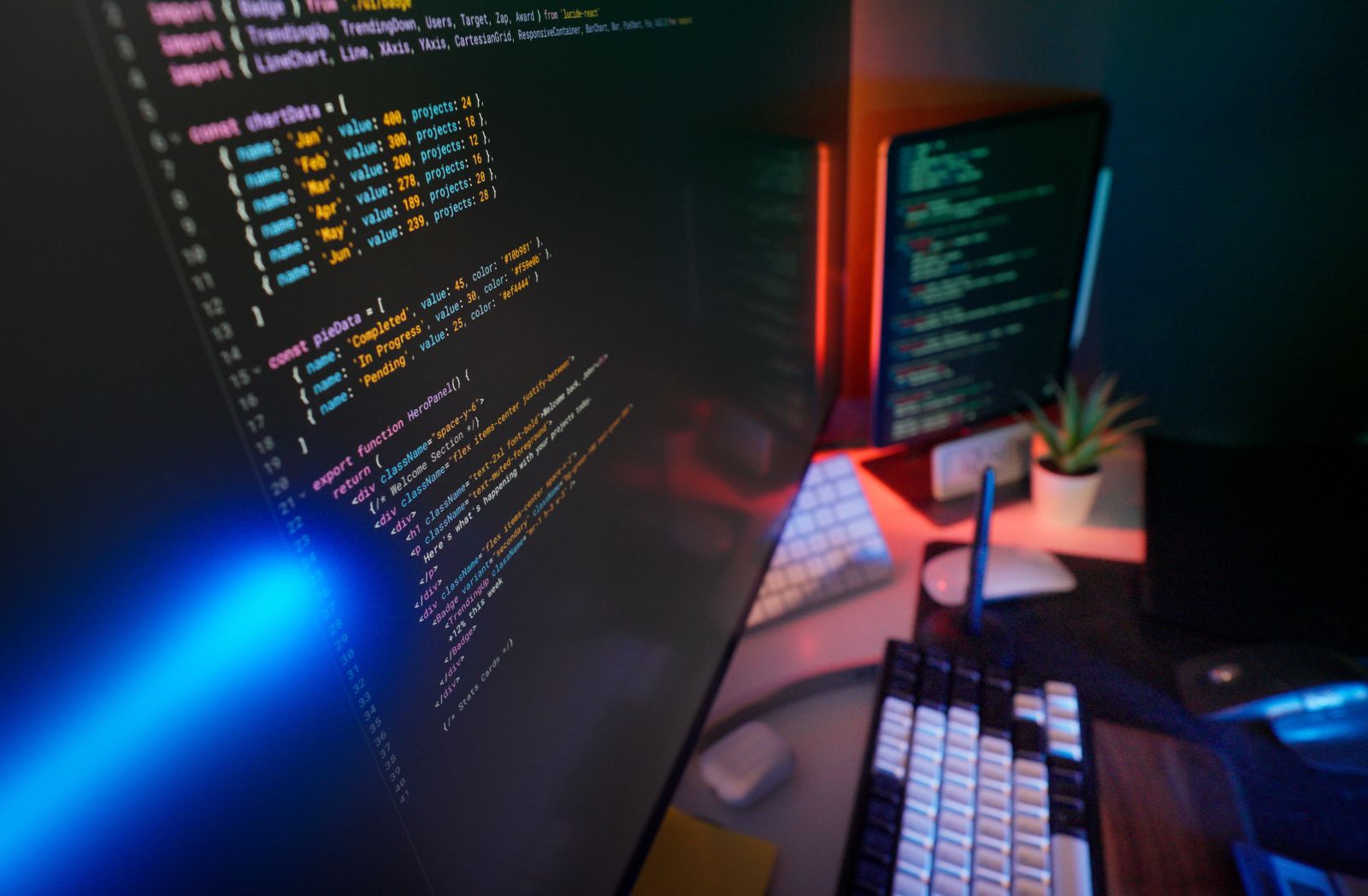 A designer's workspace with a large monitor showing colourful interface design